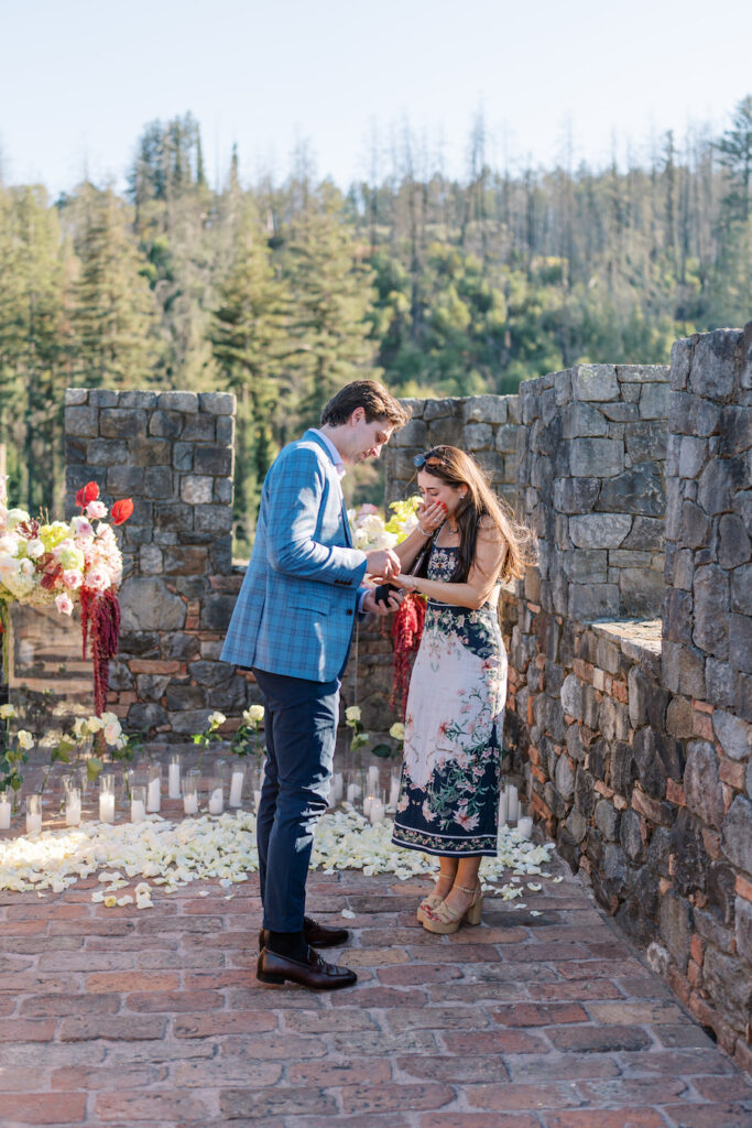 Couple embracing on the stone terrace after the proposal