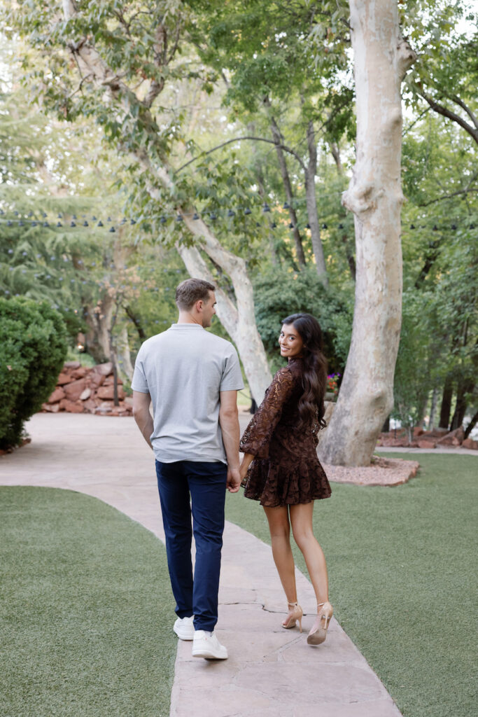 Couple walking along a garden path beneath sycamore trees
