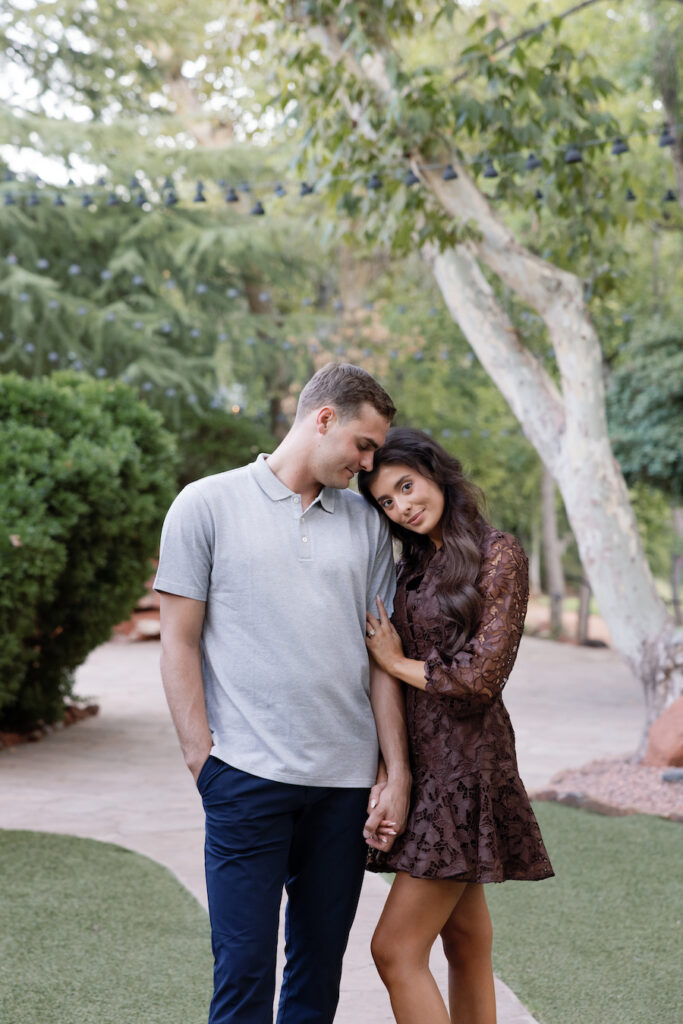 Couple leaning into each other on a tree-lined path in Sedona