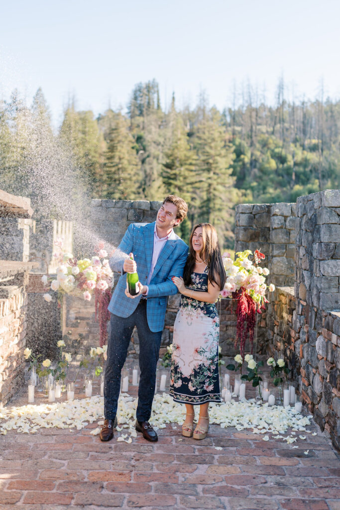 Man spraying champagne to celebrate on the castle terrace