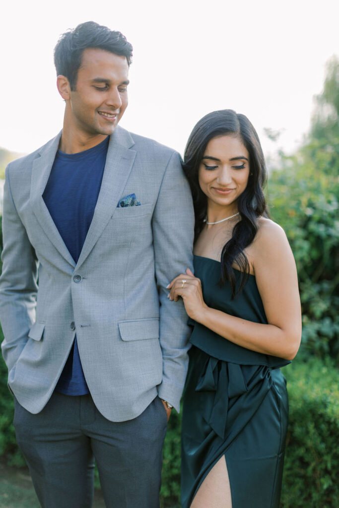 Engaged couple smiling arm in arm after the proposal