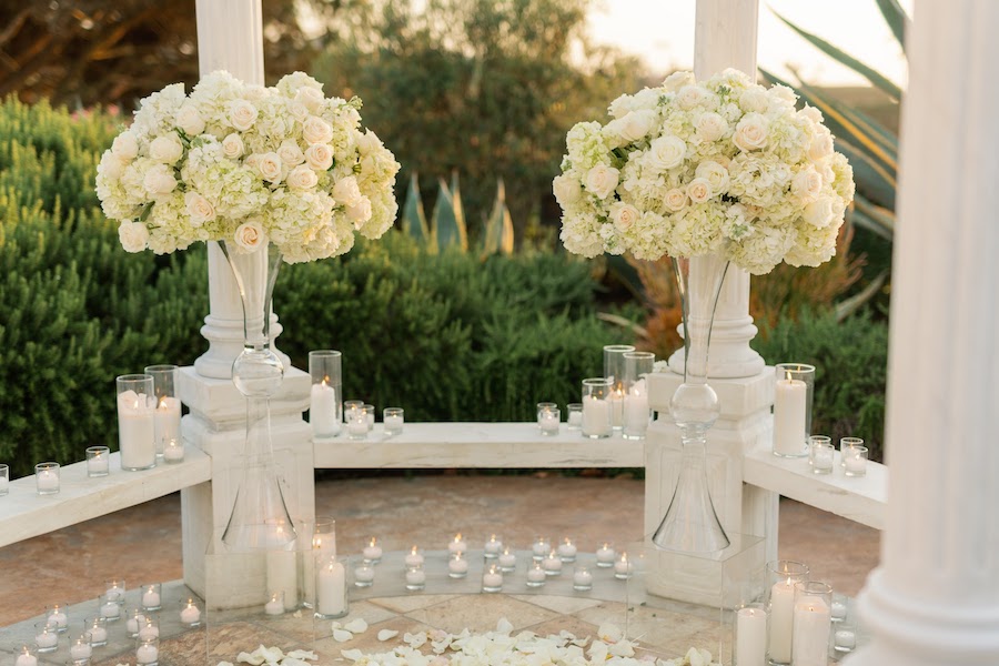 Lush white rose centerpieces framing the gazebo at an Orange County proposal