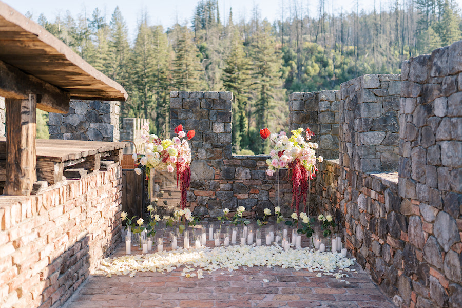 Stone castle terrace with florals and candles at a Napa vineyard castle proposal