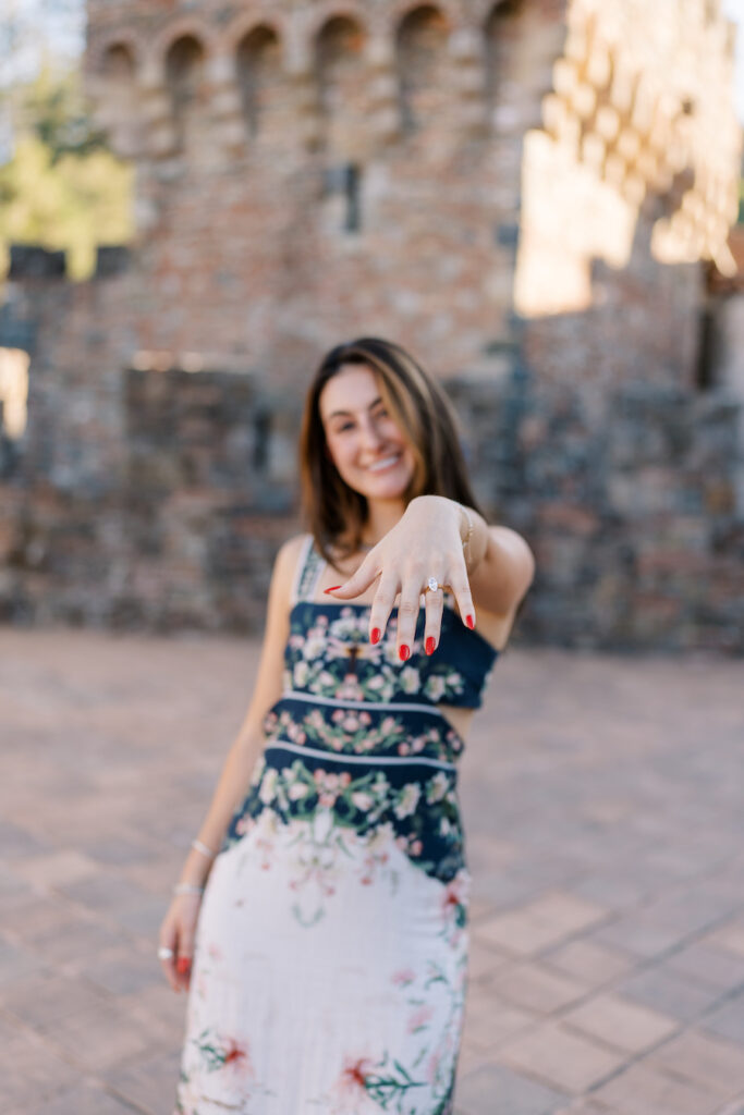 She shows off her ring in front of the castle tower