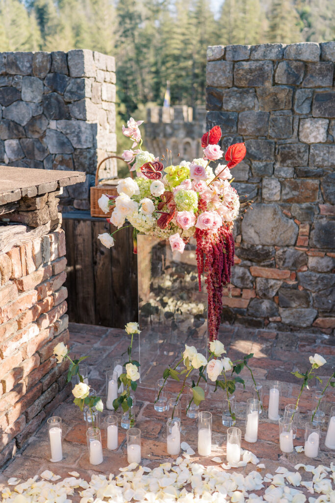 Red and blush florals framing the castle doorway with candles