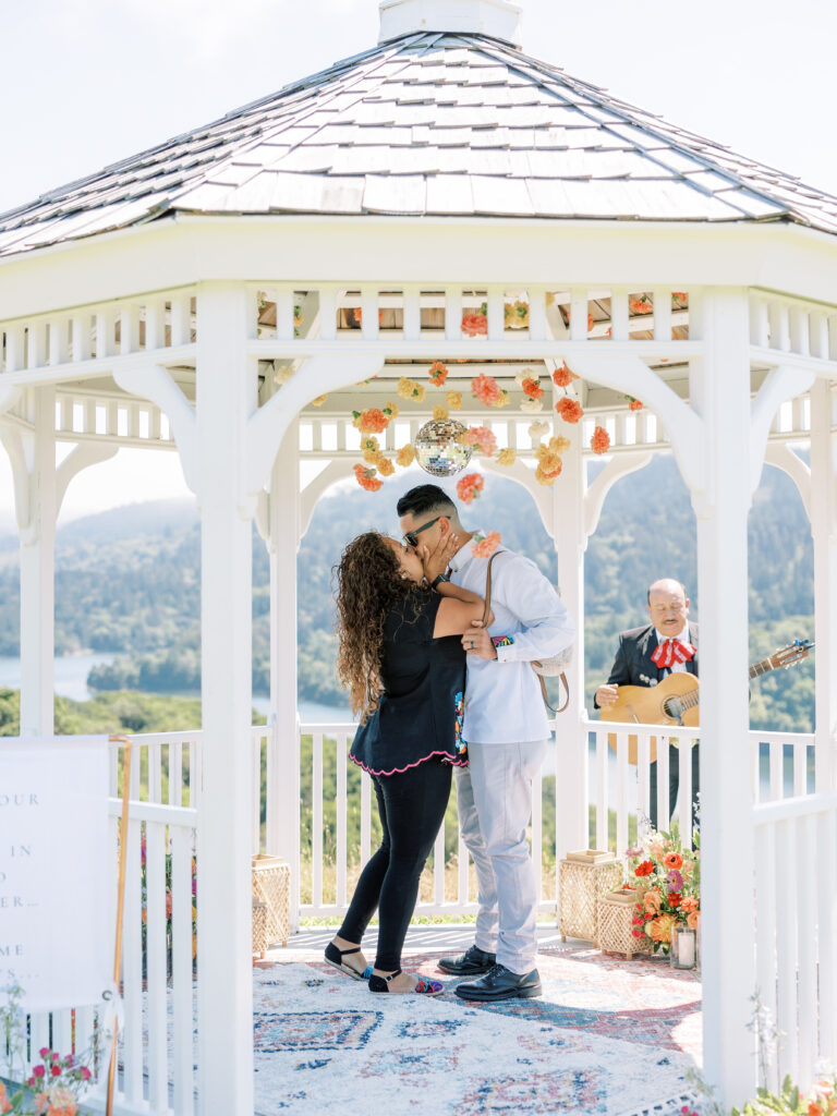 Couple kissing beneath hanging marigold garlands