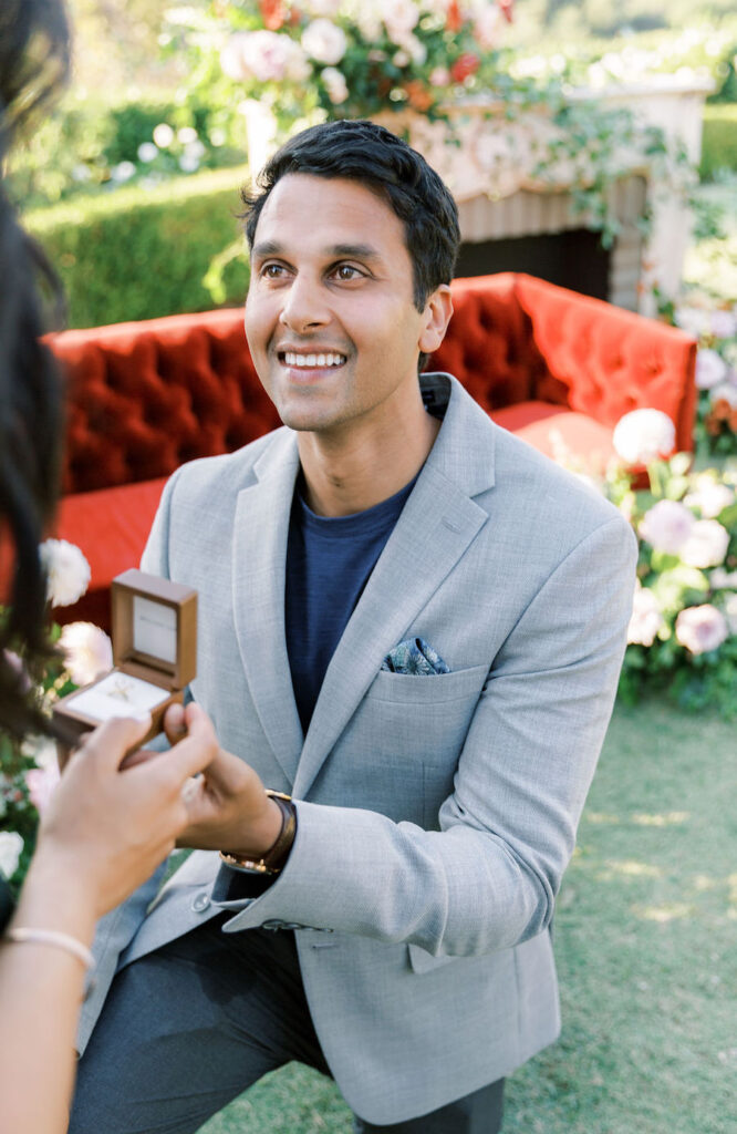 Smiling man on one knee with the ring at a custom San Diego proposal