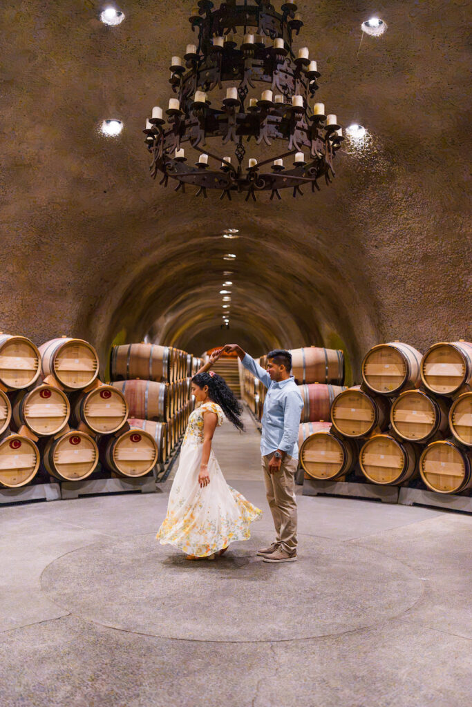 Couple in a candlelit barrel room after the proposal