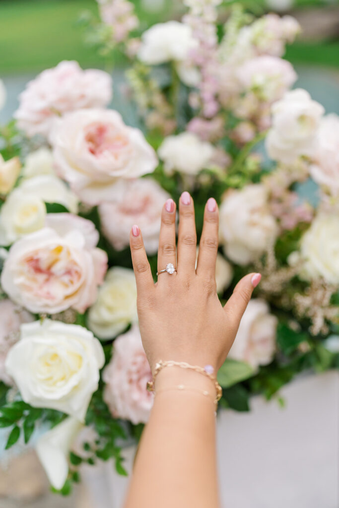 Close-up of her engagement ring against blush roses