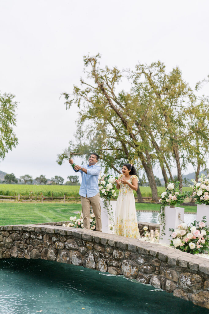 Couple on the stone bridge with florals and cascading greenery