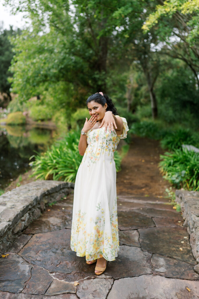 She walks along the garden path in a floral dress