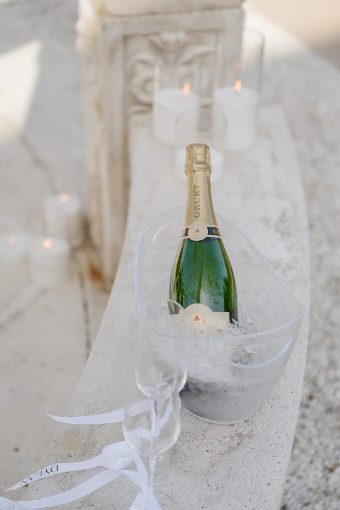 Champagne bottle and glasses tied with white ribbon