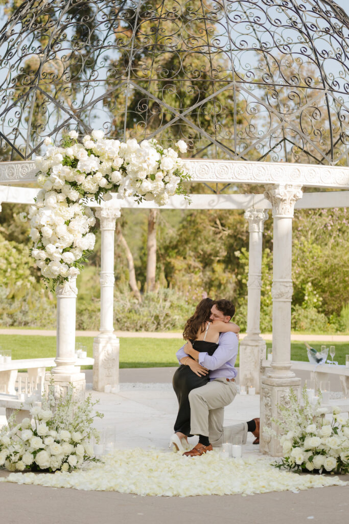 Couple embracing beneath the gazebo after she said yes