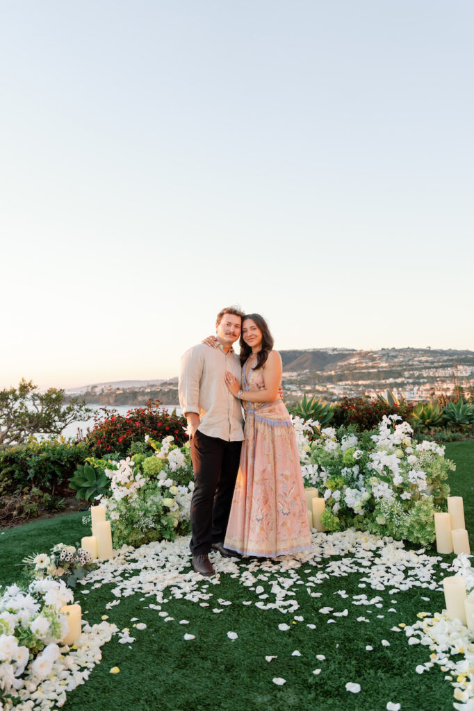 Cody and Nicole on the petal aisle framed by white florals and the coastline