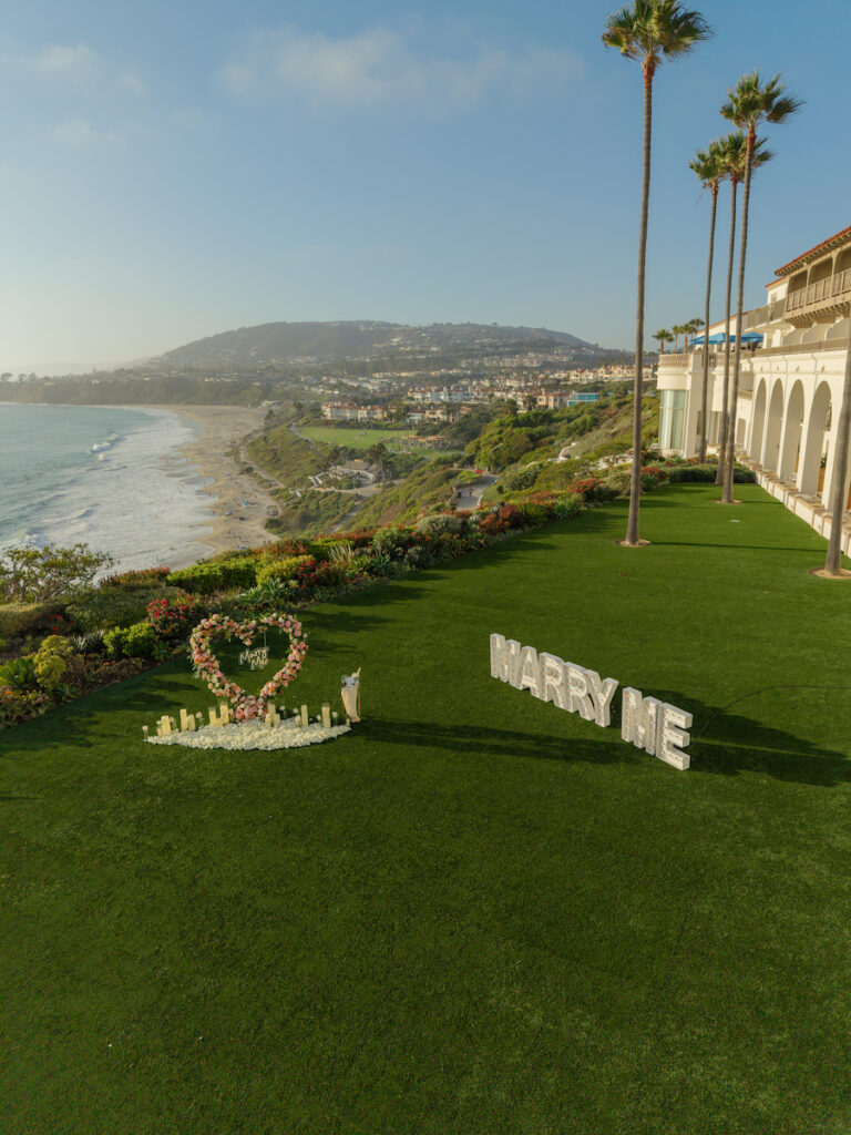 Aerial view of the heart-shaped floral arch and MARRY ME letters on the oceanfront lawn at The Ritz-Carlton, Laguna Niguel