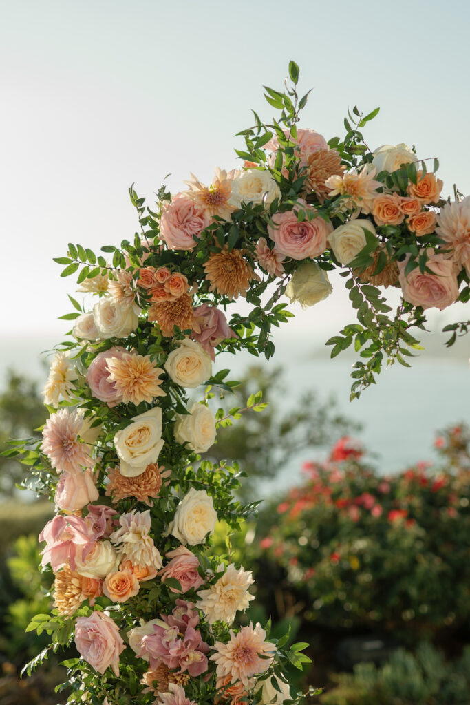 Close-up of blush, peach and ivory roses on the heart-shaped floral arch