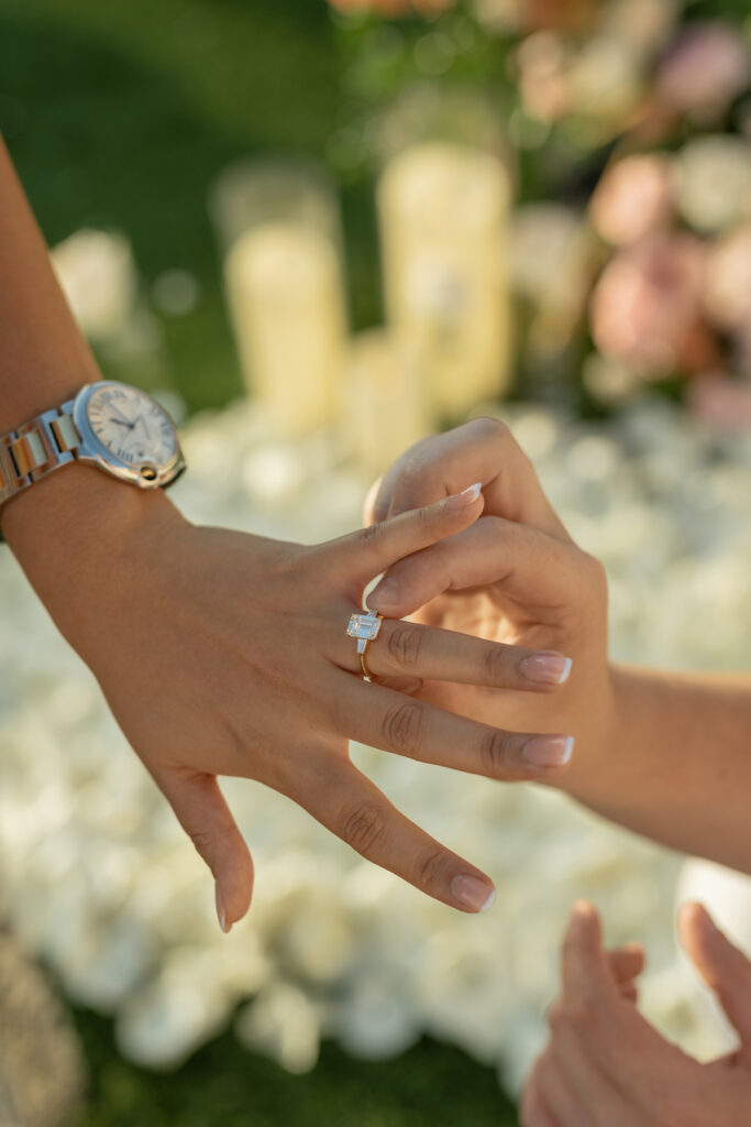 Close-up of the engagement ring being placed on her finger